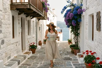 Femme explorant une ruelle pavée de Skopelos avec des maisons blanchies à la chaux et des bougainvilliers colorés en Grèce